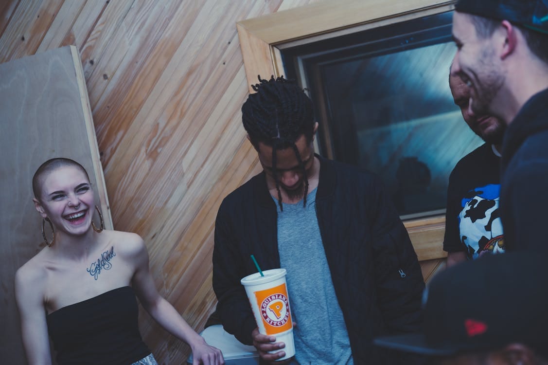 Happy diverse people laughing while drinking beverages