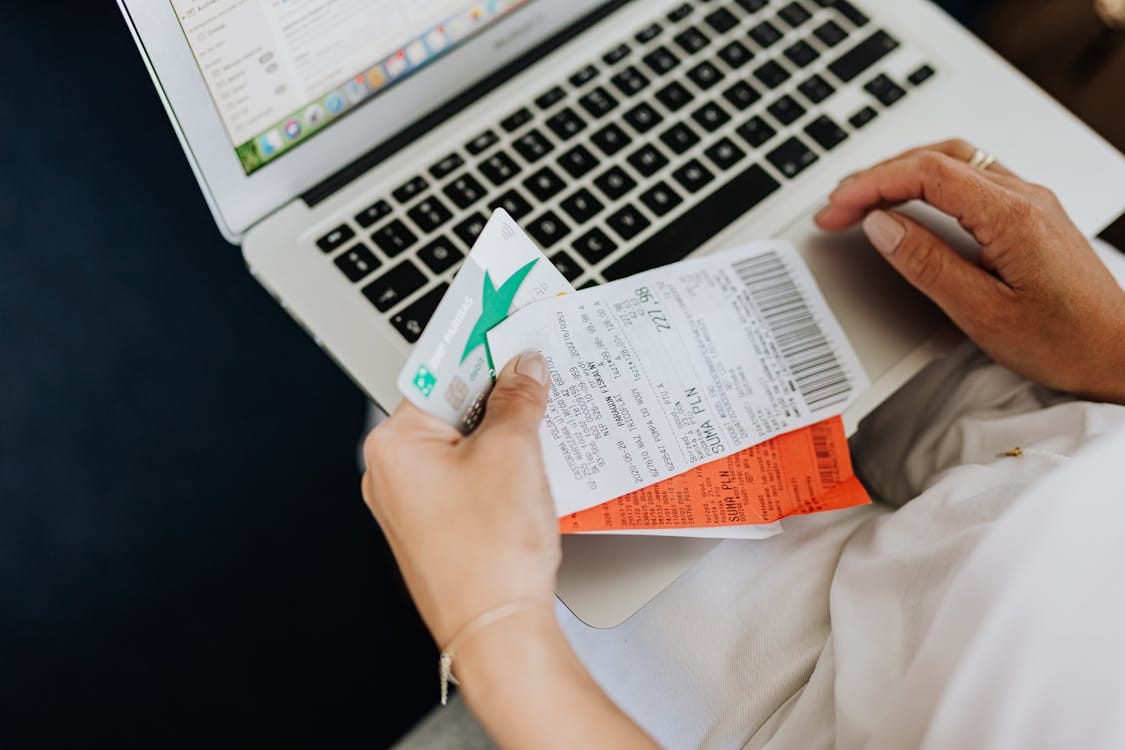 Person Using a Computer and Holding a Credit Card