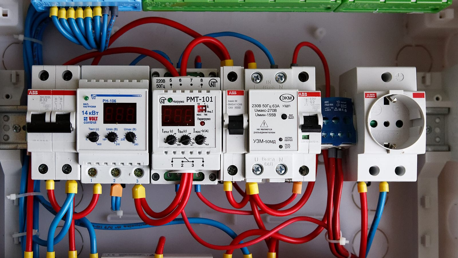 Elektrik panosundaki devre kesiciler ve renkli kablo bağlantıları
